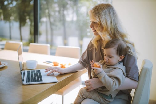 mother-working-from-home-with-child-on-her-lap