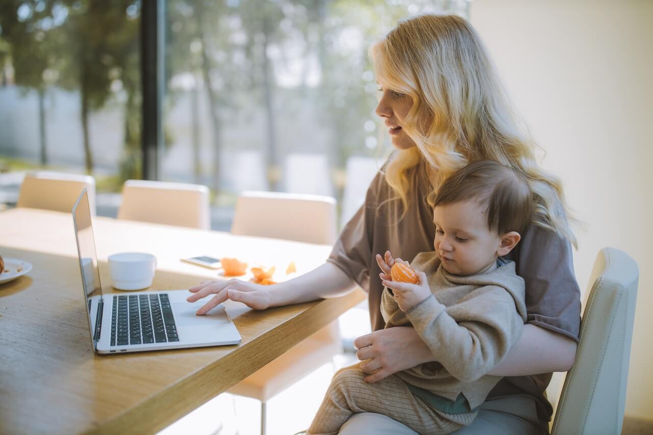 mother-working-from-home-with-child-on-her-lap
